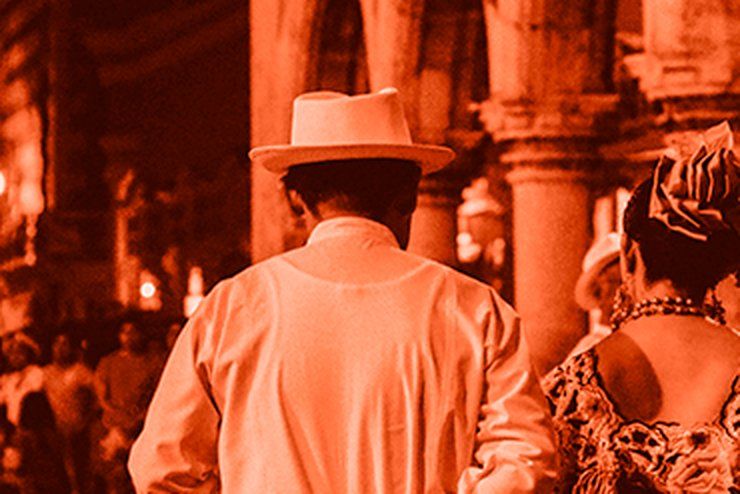 Pareja con traje regional yucateco caminando en una plaza