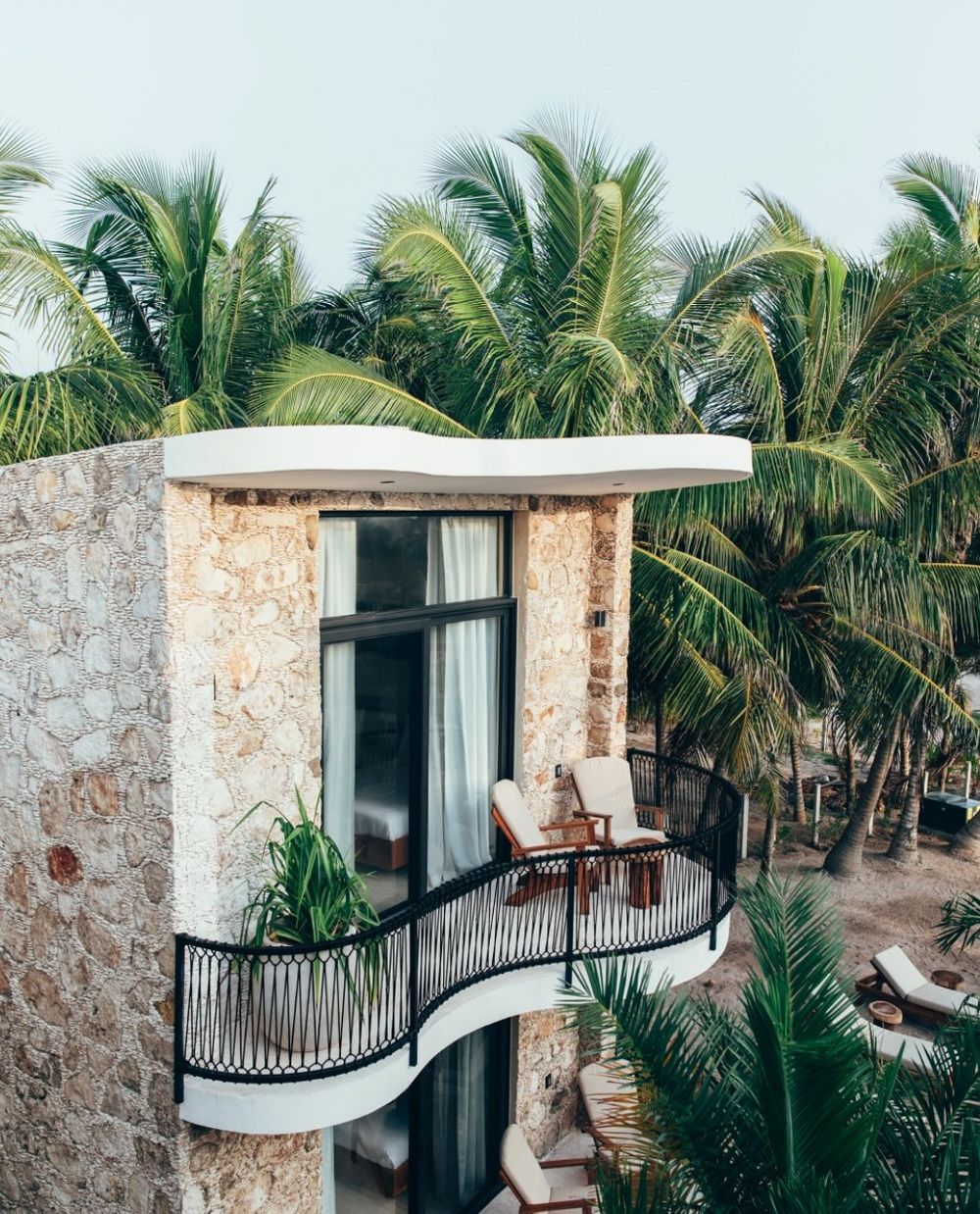 Torre de piedra con balcón entre palmeras, Cucú Hotel